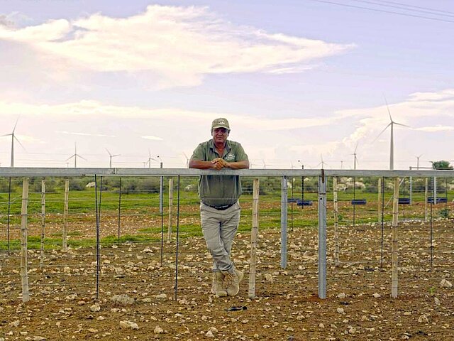 A landowner leans against the support structure of a solar park under construction